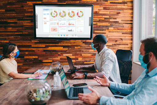 Team collaborating with digitized lean system on large digital screen with SCQD displayed with other visual information.