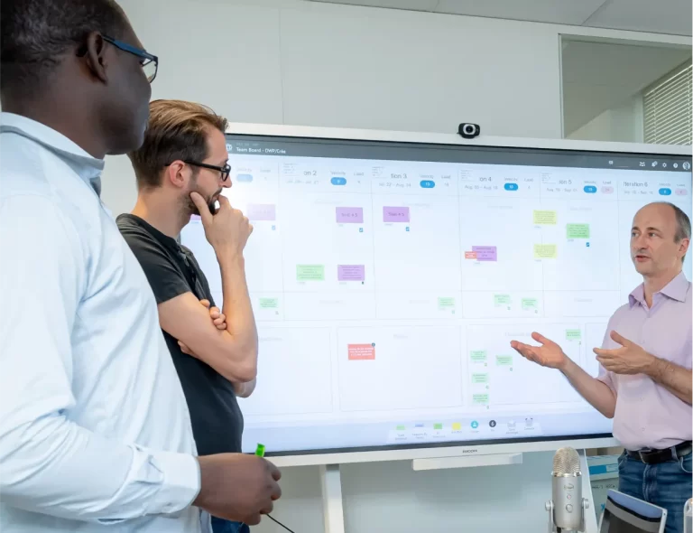 Ein Lean-Team nutzt ein Kanban-Board, das auf einem großen Bildschirm innerhalb der iObeya-Plattform dargestellt wird