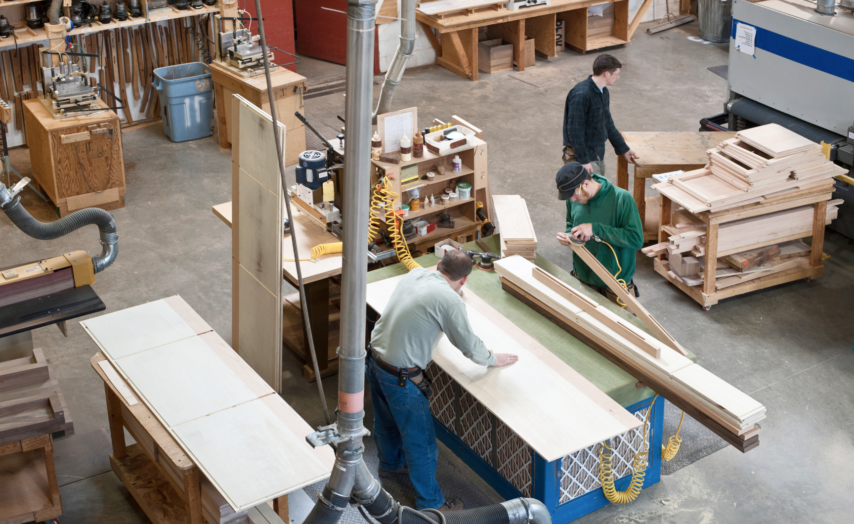 Men on small Manufacturing Shop Floor with wood working tools.